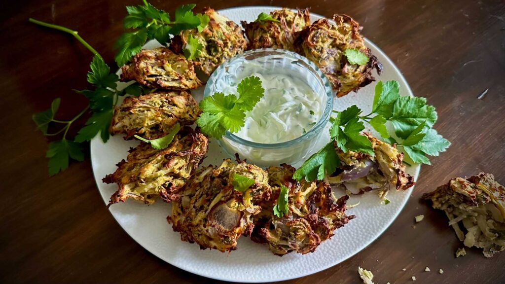 Onion bahji or pakora is a traditional Indian street food that combines thinly sliced onions with a flavorful, spicy batter to make an irresistible light, crispy, and flavorful treat for your tastebuds.