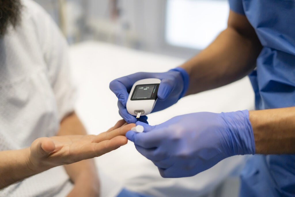 Doctor measuring blood glucose level
